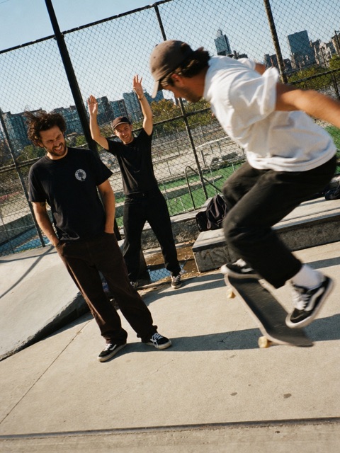 Friends cheering on a skater at an outdoor skatepark